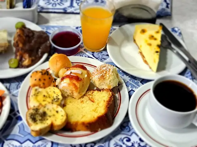 Prato do café da manhã do Hotel Itajubá: pão, queijo, frios, bolo e suco de laranja
